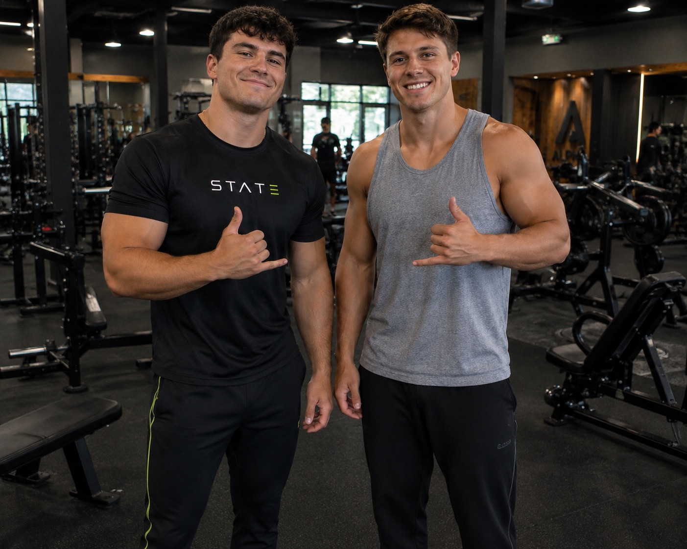 Two athletes in a gym, one wearing a black STATE tee